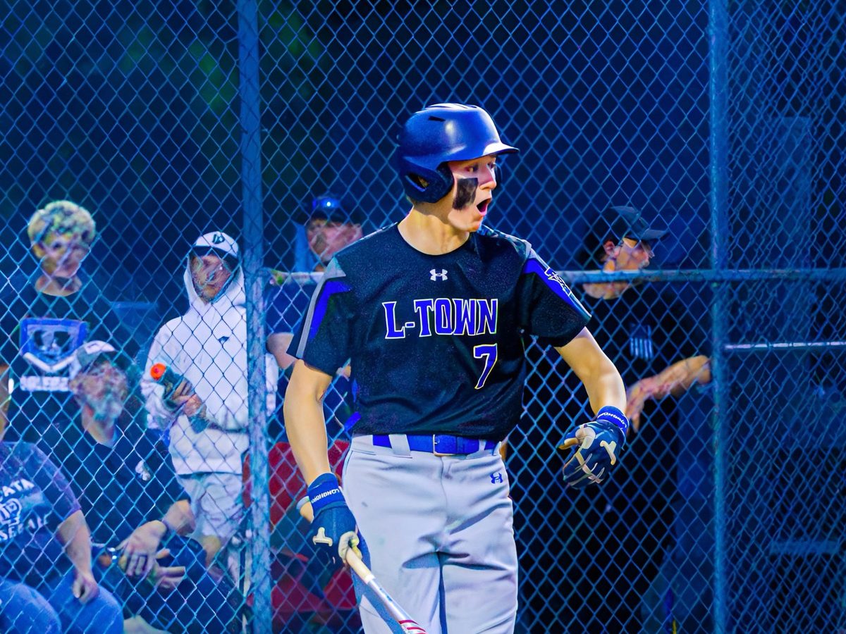 Mike Bittle at the plate at night in a black L-Town uniform, bat in hand