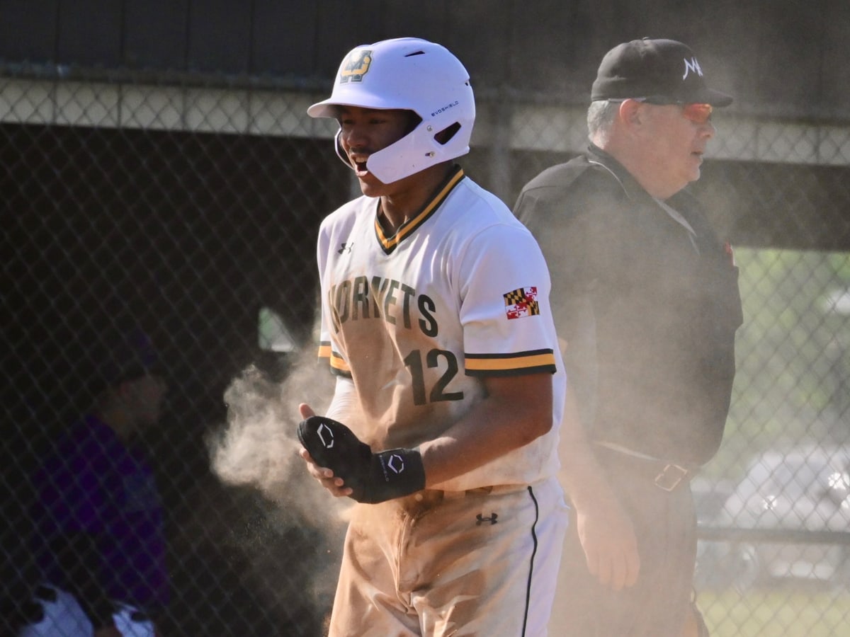 Nick Hevner shouting in celebration in a white and gold Hornets uniform, dust hanging in the air behind him